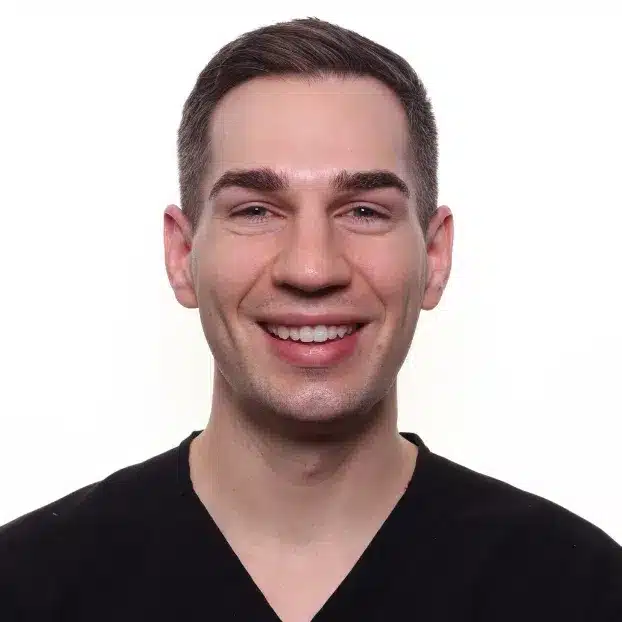 Illinois orthodontist Dr. Bond smiling in black scrubs