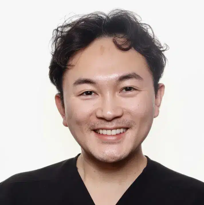 Illinois orthodontist Dr. Chen smiling in black scrubs