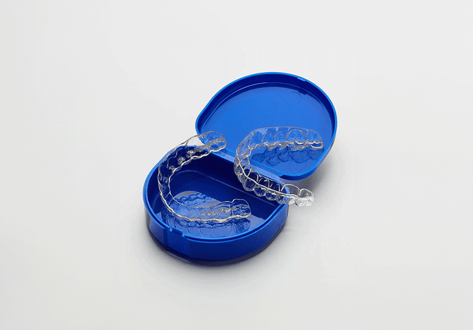 A set of clear plastic retainers in a blue case on a white table