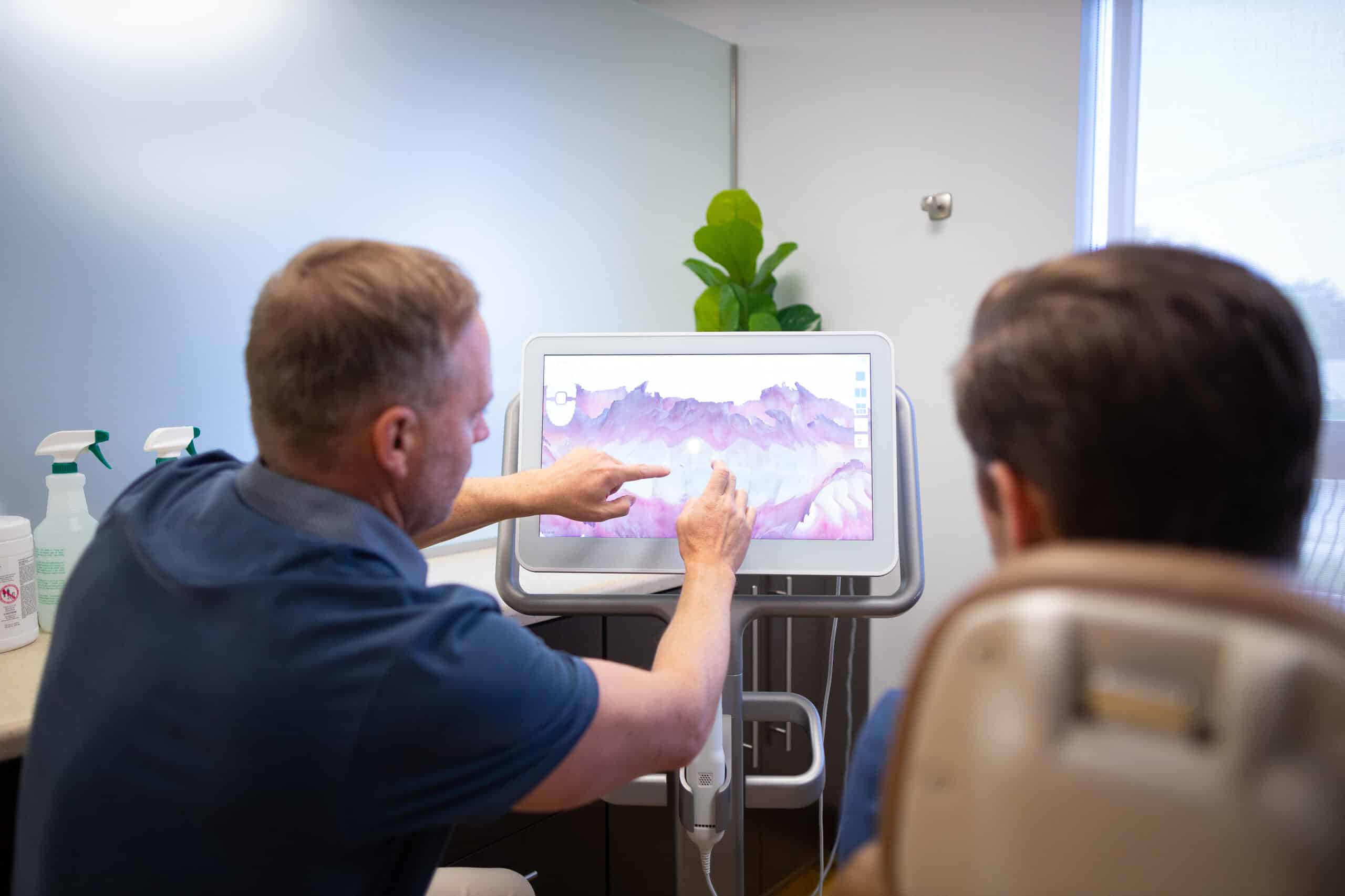 Speaking with a client about their teeth using a dental model